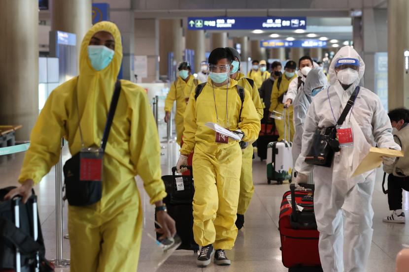 Penumpang yang mengenakan alat pelindung tiba di Bandara Internasional Incheon, di Incheon, Korea Selatan, 29 November 2021, karena otoritas kesehatan telah memberlakukan larangan masuk bagi kedatangan asing dari delapan negara Afrika, termasuk Afrika Selatan, untuk memblokir masuknya COVID-19 baru varian omicron