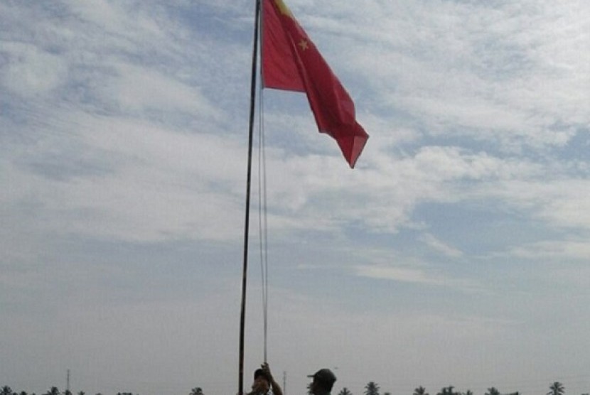 Penurunan bendera Cina oleh petugas keamanan PT Asri Gita Prasarana dan Babinsa KoramiL Mariana.