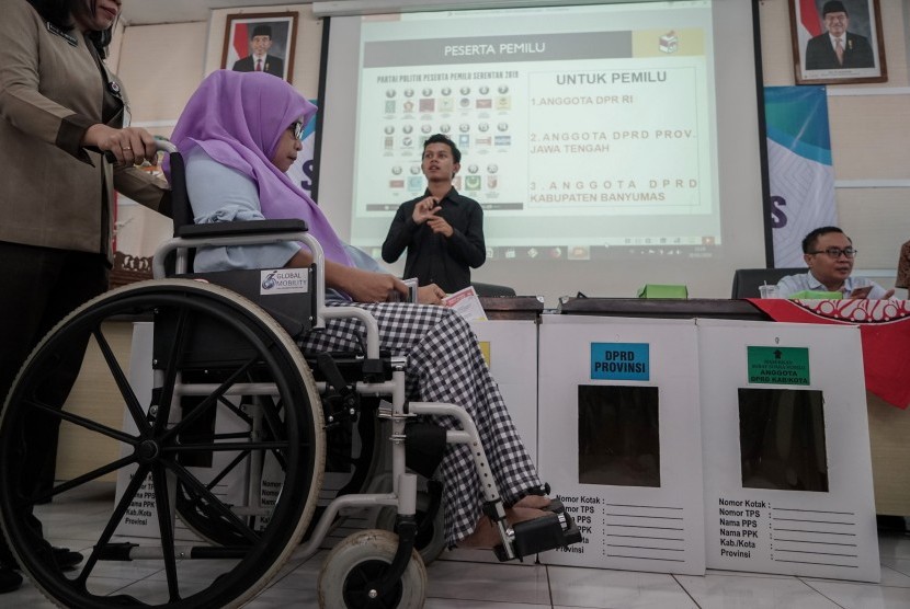 Penyandang difabel memasukkan contoh surat suara, saat simulasi pencoblosan bagi penyandang difabel oleh KPU Banyumas, di Aula Dinsos Banyumas, Jawa Tengah, Rabu (20/2/2019).