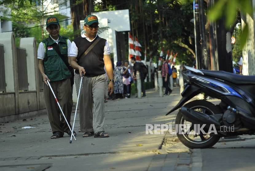 Penyandang disabilitas dari komunitas netra berjalan ditrotoar saat aksi pemantauan fasilitas akses penjalan kaki atau pedestrian untuk disabilitas di Kawasan Kebon Sirih, Jakarta, Rabu (30/8). 