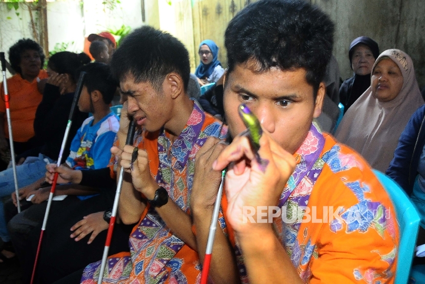  Penyandang disabilitas menunjukan tinta suara pada jarinya seusai pencoblosan pada Pilkada Gubernur dan Wakil Gubernur DKI Jakarta Tahun 2017 di TPS 07 Kelurahan Cawang, Jakarta, Rabu (15/2).