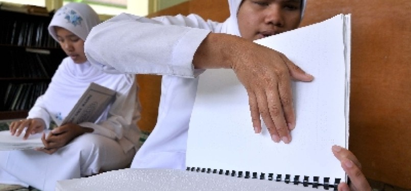 Penyandang tunanetra membaca Alquran braille.