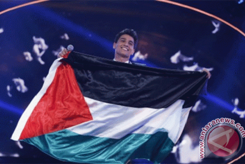 Penyanyi asal Palestina Mohamed Assaf membawa bendera negaranya, saat berdiri diatas panggung usai dinobatkan sebagai pemenang final 