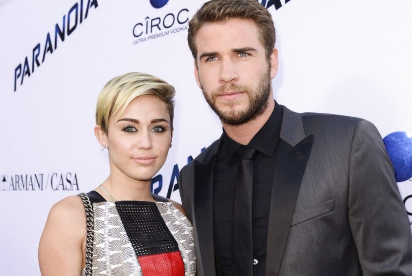 Penyanyi dan aktris Miley Cyrus bersama aktor Liam Hemsworth pada 2013.
