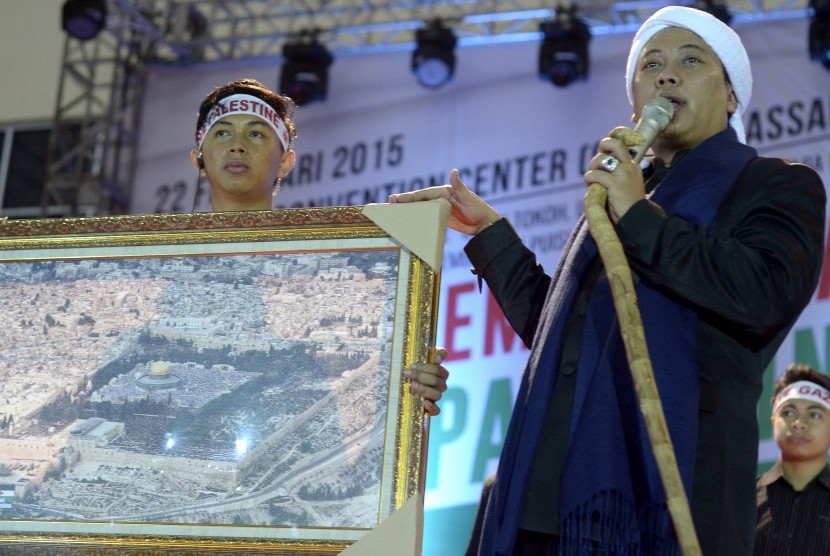 Penyanyi religi Opick melelang sejumlah barang saat tampil dalam konser Kemanusiaan Peduli Palestina di Celebes Convention Centre, Makassar, Sulawesi Selatan, Minggu (22/2).
