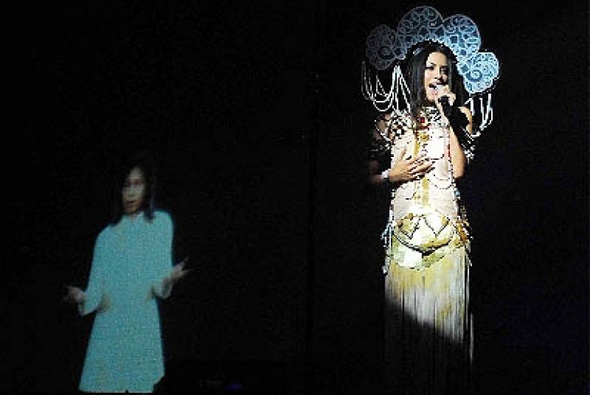 Penyanyi, Sophia Latjuba (kanan) dengan latar belakang tampilan visual almarhum Chrisye dalam Konser 