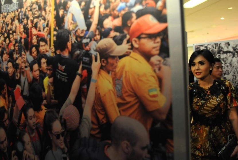 Penyanyi Yuni Shara mengamati pameran foto bertajuk Musik Untuk Demokrasi di Main Atrium East Mall Grand Indonesia, Jakarta, Selasa (14/10).