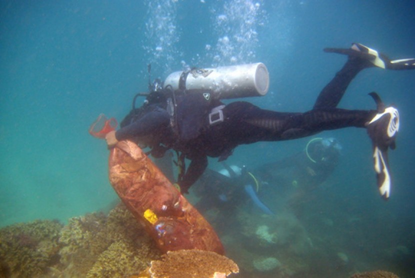 Penyelam profesional membersihkan sampah di bawah Laut Nusa Dua