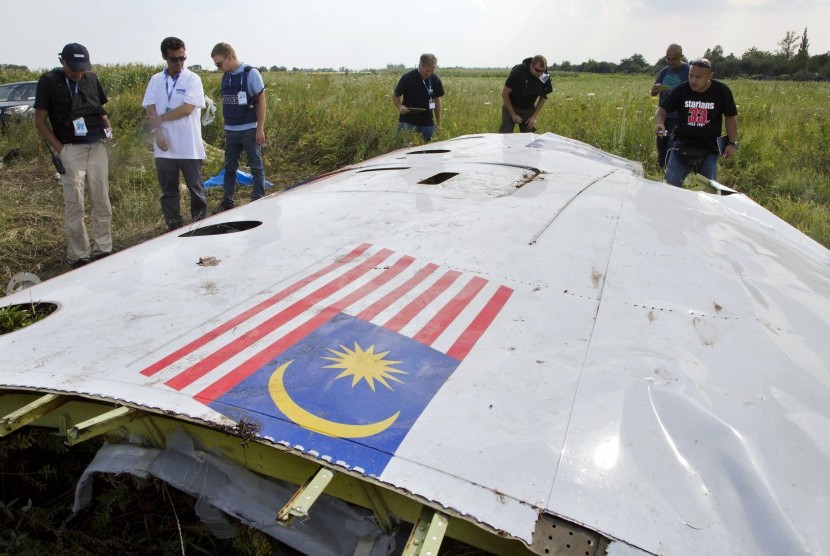 Penyelidik Malaysia sedang memerika puing pesawat Malaysia Airlines MH17 yang jatuh di wilayah Ukraina