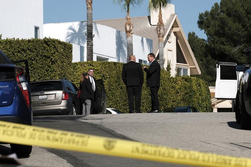 Penyelidik polisi berdiri di sebuah jalan dekat sebuah rumah di mana tiga orang tewas dan empat lainnya terluka di sebuah rumah di lingkungan kelas atas Los Angeles pada Sabtu 28 Januari 2023.