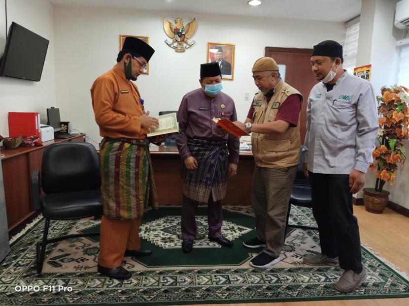 Penyerahan Alquran secara simbolis dari Badan Wakaf Alquran (BWA) kepada Kepala Biro Kesra Provinsi Riau, H Zulkifli Syukur SAg,  MA, MSi..