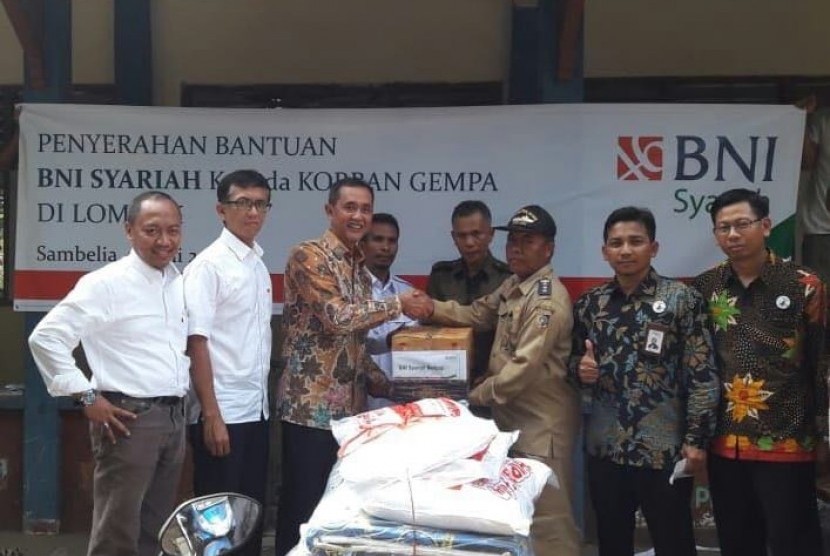 Penyerahan Bantuan BNI Syariah kepada Korban Gempa di Desa Obel – Obel, Sambelia, Lombok Timur, NTB (kiri – kanan) Pemimpin Wilayah Timur, Imam Hidayat Sunarto; Pemimpin Divisi Layanan dan Jaringan, Adjat Djatnika; SEVP Bisnis Retail dan Jaringan, Iwan Abdi menyerahkan bantuan kepada Camat Simbelia, Drs. Zaitul Akmal MM ditemani oleh Pemimpin Cabang BNI Syariah Cakranegara Mataram, Agus Nugroho; dan Pemimpin Cabang BNI Syariah Mataram, Mansyur (30/7).