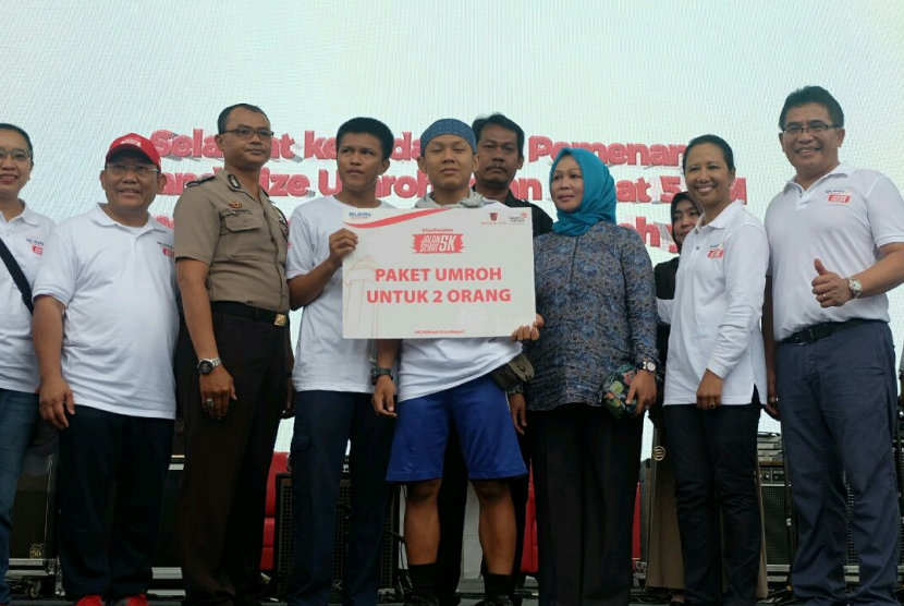 Penyerahan grand prize berupa paket umroh kepada salah satu peserta beruntung di acara  Jalan Sehat 5K di Kota Serang, Ahad (13/8). 