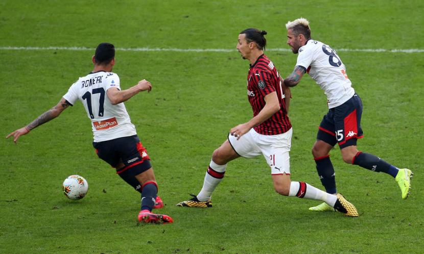 Penyerang AC Milan Zlatan Ibrahimovic (tengah) diapit dua pemain Genoa dalam laga Liga Italia di San Siro, Ahad (8/3). Ibrahimovic mencetak gol ke gawang Genoa, tapi Milan tetap kalah 1-2.