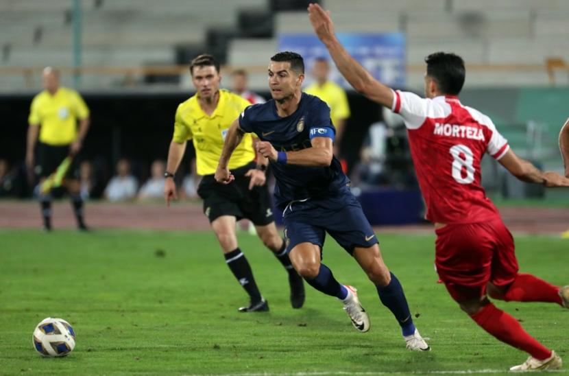 Penyerang Al Nassr Cristiano Ronaldo (kiri) menggiring bola melewati pemain Persipolis Morteza Pouraliganji dalam laga LIga Champions Asia. Al Nassr menang 2-0.