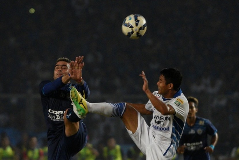 Penyerang Arema Cronus Cristian Gonzales (kiri) berduel dengan pemain Persib Purwaka Yudi.