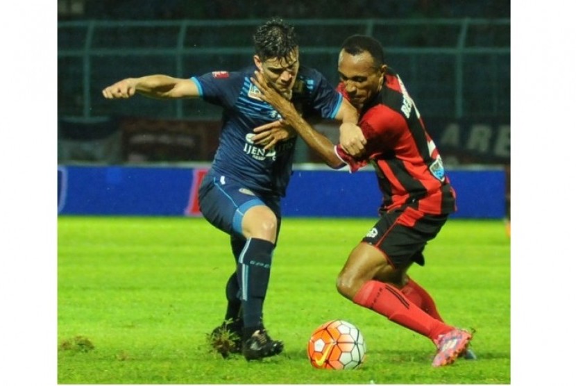 Penyerang Arema Cronus Gustavo Giron (kiri) berdue bola dengan bek Persipura Rony Beroperay