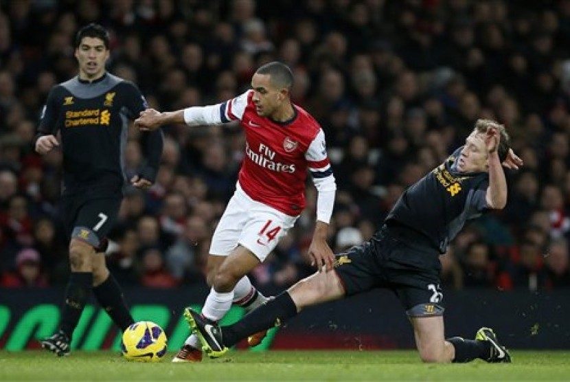 Penyerang Arsenal Theo Walcott (tengah) berebut bola dengan gelandang Liverpool Lucas Leiva pada lanjutan Liga Primer Inggris di Emirates Stadium, Kamis (31/1) dini hari. Laga itu berakhir 2-2.