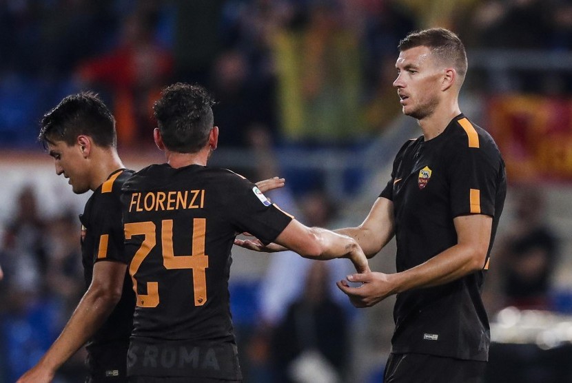 Penyerang AS Roma Edin Dzeko bersama rekan setimnya Alessandro Florenzi setelah melesakkan gol keduanya pada lanjutan Liga Italia Serie A di Stadion Olimpico, Sabtu (16/9). Roma mengalahkan Hellas Verona dengan skor 3-0. 