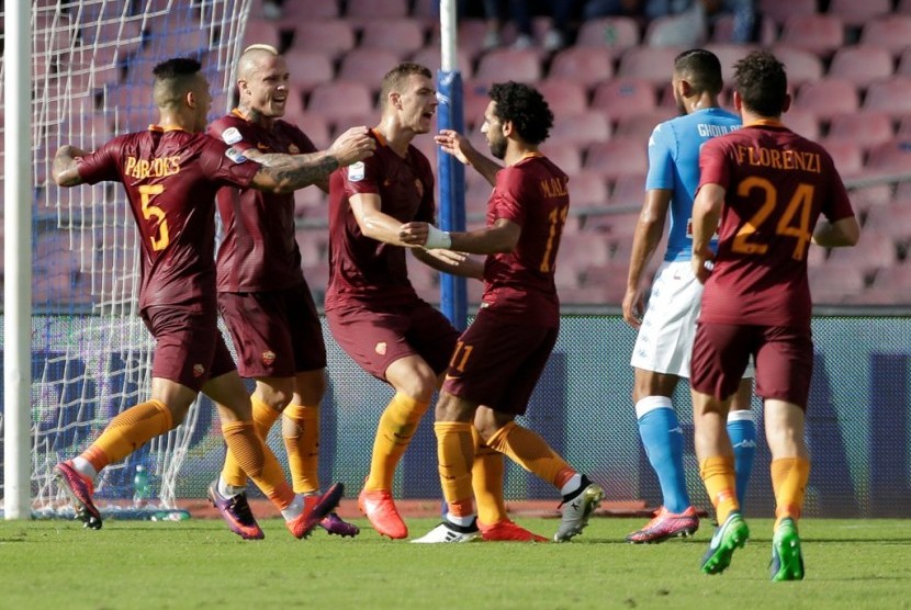 Penyerang AS Roma Edin Dzeko (tengah) merayakan golnya bersama rekan-rekannya seusai menjebol gawang Napoli dalam pertandingan Serie A di Stadion San Paolo, Sabtu (15/10).