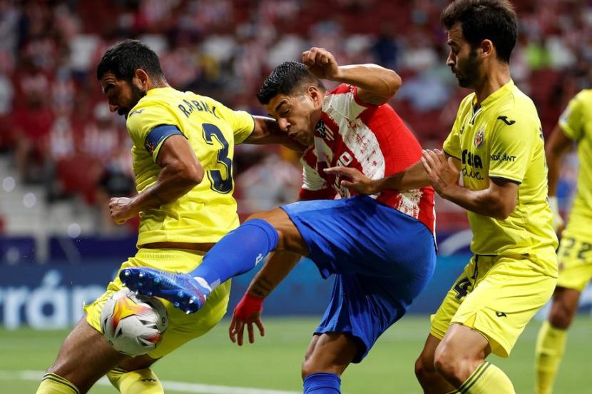 Penyerang Atletico madrid Luis Suarez (tengah) berebut bola dengan para pemain Villarreal.