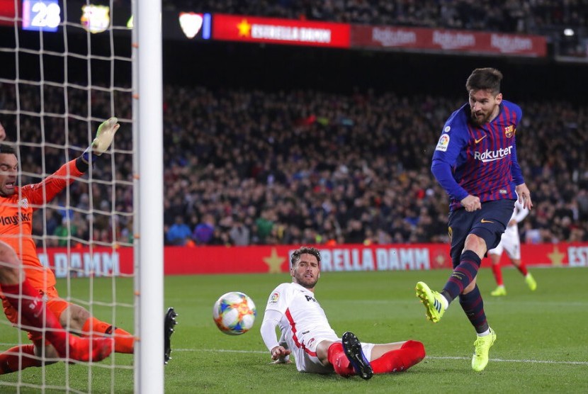 Penyerang Barcelona Lionel Messi melepaskan tendangan ke gawang Sevilla.