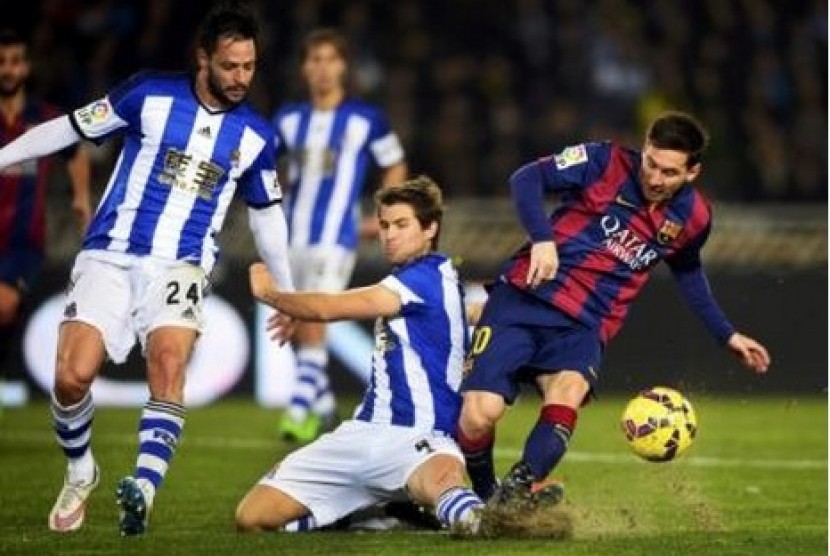 Penyerang Barcelona Lionel Messi saat berusaha melewati pertahanan Real Sociedad, Senin (5/1) dini hari WIB.