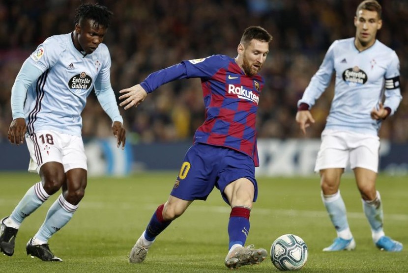 Penyerang Barcelona Lionel Messi (tengah) dijaga dua pemain Celta Vigo.