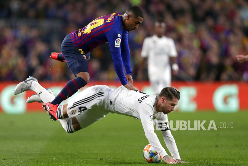 Penyerang Barcelona Malcom berduel dengan bek Real Madrid Sergio Ramos pada leg pertama semifinal Copa del Rey di stadion Camp Nou di Barcelona, Spanyol, Rabu (6/2/2019). 