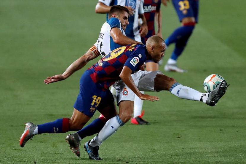 Penyerang Barcelona Martin Braithwaite berjibaku dengan pemain Espanyol. Barcelona menang 1-0 yang membuat Espanyol terdegradasi ke Divisi Segunda musim depan.