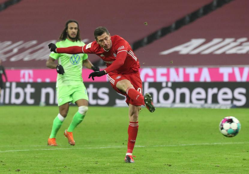 Penyerang Bayern Muenchen Robert Lewandowski mencetak gol ke gawang Vfl Wolfsburg.