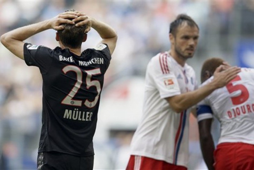 Penyerang Bayern Muenchen Thomas Mueller (kiri) mengekspresikan kekecewaan akibat gagal memetik kemenangan saat menghadapi Hamburger SV, Sabtu (20/9) di Bundesliga.