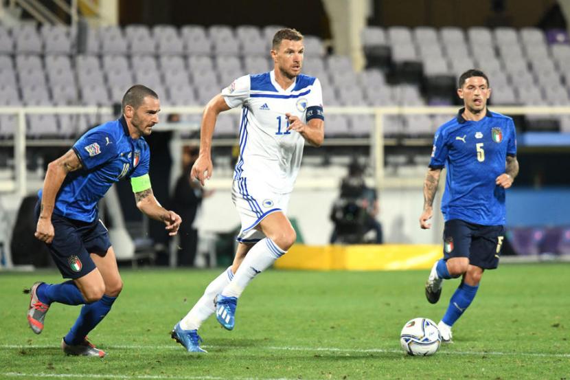 Penyerang Bosnia Herzegovina Edin Dzeko (tengah) diapit dua pemain Italia dalam laga UEFA Nations League.