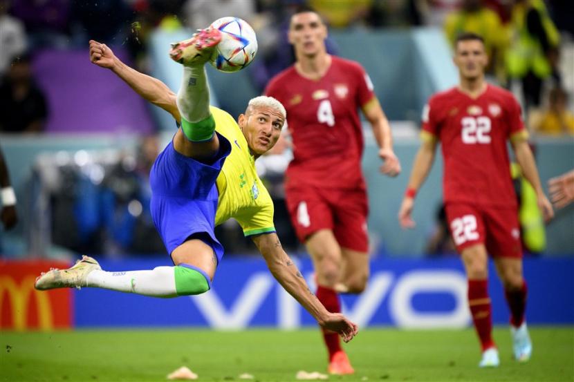  Penyerang Brasil Richarlison (Kiri) mencetak skor 2-0 di depan bek Serbia Nikola Milenkovic (Tengah) dan gelandang Serbia Darko Lazovic (Kanan) selama pertandingan sepak bola grup G Piala Dunia FIFA 2022 antara Brasil dan Serbia di Stadion Lusail di Lusail, Qatar, Kamis, 24 November 2022. 
