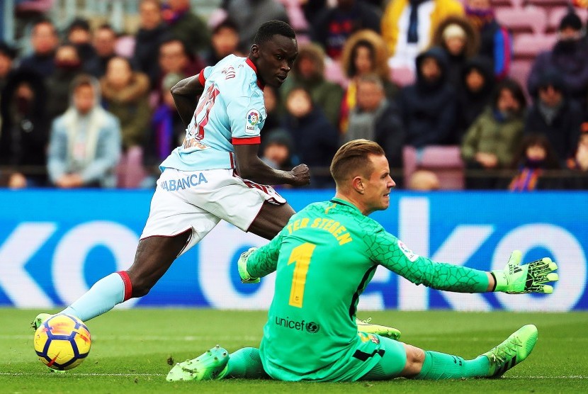 Penyerang Celta Vigo asal Denmark Pione Sisto (kiri) beraksi menghadapi kiper FC Barcelona asal Jerman Marc-Andre ter Stegen (kanan) saat pertandingan La Liga di Camp Nou di Barcelona, Spanyol, Sabtu (2/12). 