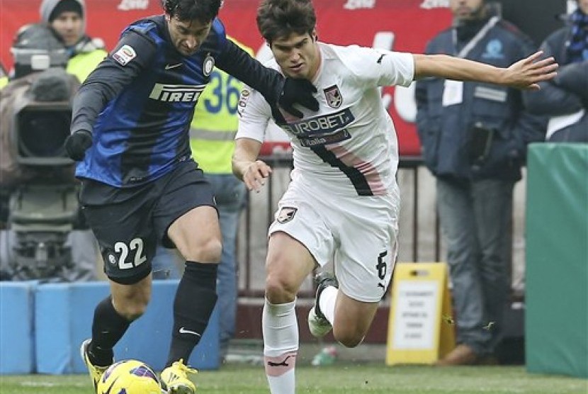 Penyerang Inter Milan, Diego Milito, berebut bola dengan bek Palermo, Ezequiel Munoz, di Guiseppe Meazza, Ahad (3/12) malam. Inter menang 1-0 pada pertandingan tersebut.