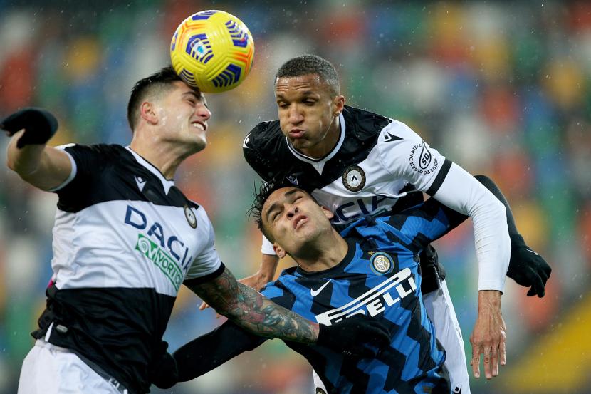 Penyerang Inter Milan Lautaro Martinez (tengah) Inter berduel dengan dua pemain Udinese, Kevin Bonifazi dan Rodrigo Becao (kanan). 