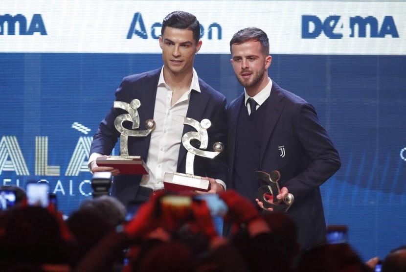 Penyerang Juventus Cristiano Ronaldo (kiri) saat menerima penghargaan Pemain Terbaik Liga Italia, Selasa (3/12) dini hari WIB. Ronaldo absen pada acara seremoni Ballon d'Or 2019 di Paris.