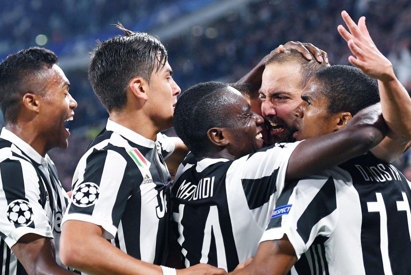 Penyerang Juventus Gonzalo Higuain dipeluk oleh rekan setimnya setelah melesakkan gol pembuka pada laga Liga Champions Grup B antara Juventus dan Olympiakos SFP di Stadion Allianz, Turin, Italia, Kamis (28/9) dini hari WIB. Juve menang 2-0. 