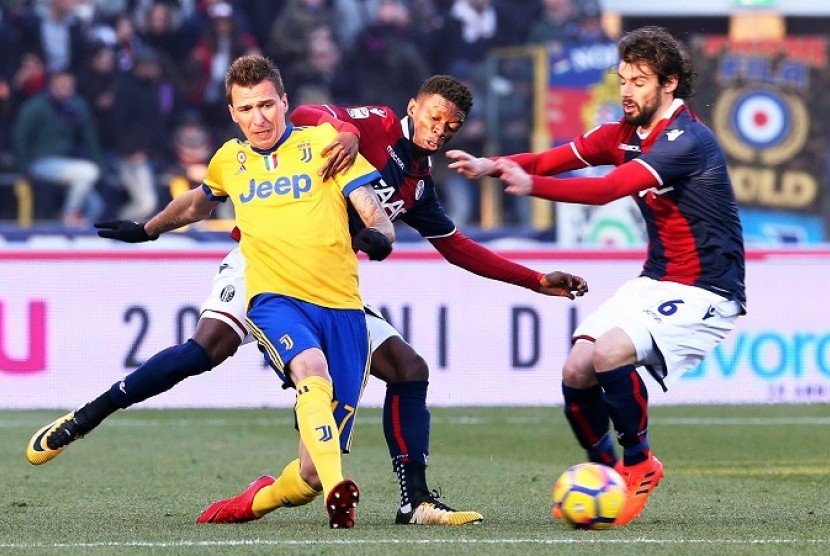 Penyerang Juventus, Mario Mandzukic (kiri) saat menghadapi Bologna dalam laga lanjutan Serie A, Ahad (17/12).