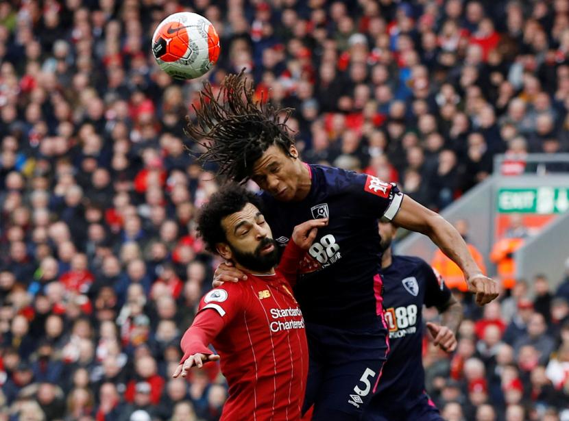 Penyerang Liverpool Mohamed Salah berebut bola dengan pemain Bournemouth Nathan Ake dalam laga lanjutan liga Inggris, Sabtu (7/3). 