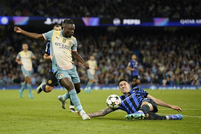 Penyerang Manchester City Jeremy Doku (kiri) ditantang oleh pemain Inter Milan Alessandro Bastoni dalam pertandingan Liga Champions di Stadion Etihad, Manchester, Kamis (19/9/2024) dini hari WIB.