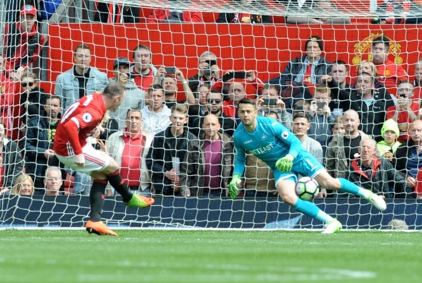 Penyerang Manchester United Wayne Rooney (kiri) mencetak gol ke gawang Swansea City lewat tendangan penalti.