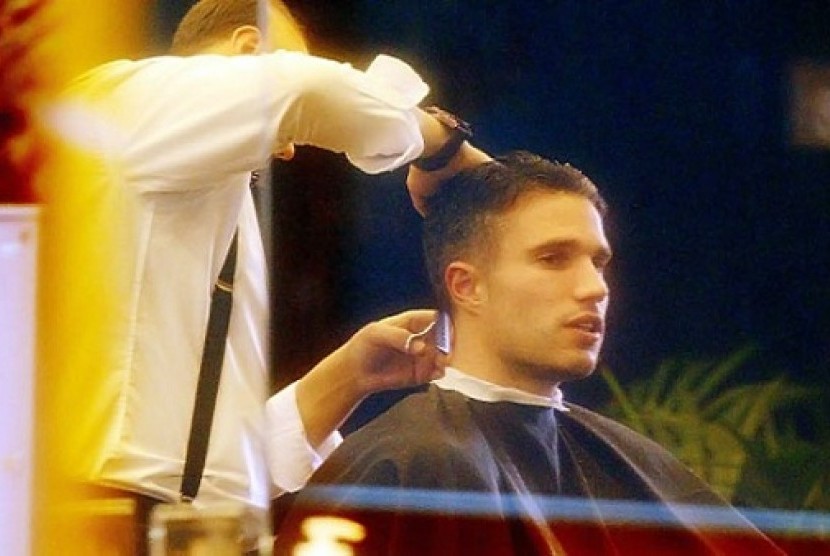 Penyerang MU, Robin Van Persie sedang memangkas rambut