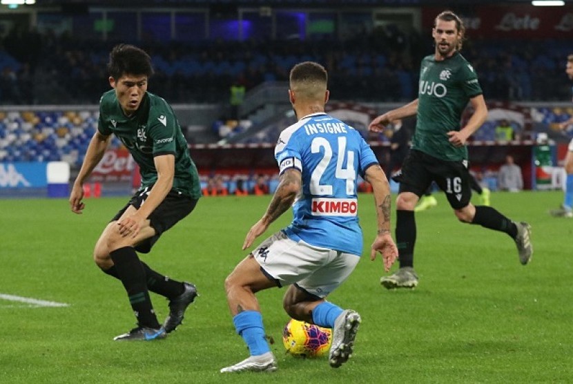 Penyerang Napoli Lorenzo Insigne mencoba melewati pemain Bologna Takehiro Tomiyasu dalam pertandingan di Stadion San Paolo, Senin (2/12) dini hari WIB.