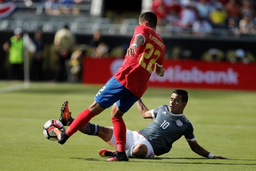 Penyerang Paraguay Derlis Gonzalez (kanan) dan bek Kosta Rika Ronald Matarrita berebut bola. 