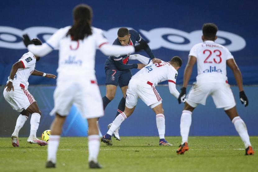 Penyerang Paris Saint Germain (PSG) Kylian Mbappe dijaga para pemain Olympique Lyon. PSG takluk 0-1 dari Lyon dalam lanjutan Ligue 1 Prancis. 
