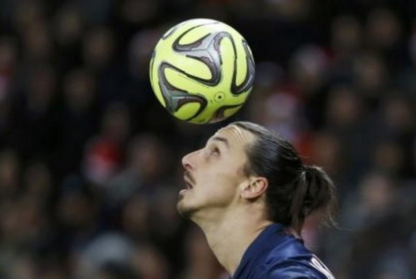 Penyerang Paris Saint-Germain Zlatan Ibrahimovic menanduk bola dalam laga melawan Montpellier, Sabtu (20/12).