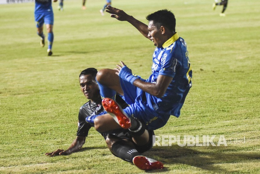 Penyerang Persib Bandung Frets Listianto Butuan (kanan) terjatuh saat pertandingan Sepak Bola Liga 1 2019 di Stadion Si Jalak Harupat, Kabupaten Bandung, Selasa (18/6). 
