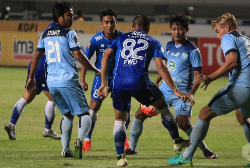 Penyerang Persib Tantang (tengah) berusaha merebut bola di tengah kepungan pemain Persela Lamongan.